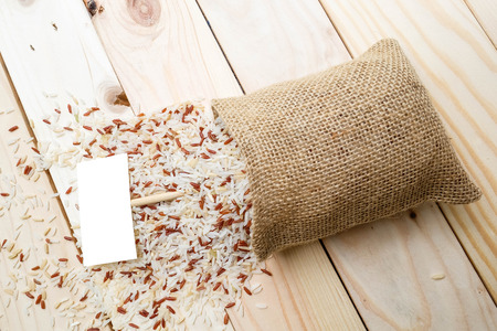 Half polished rice and jasmine rice spill out from the sackの写真素材