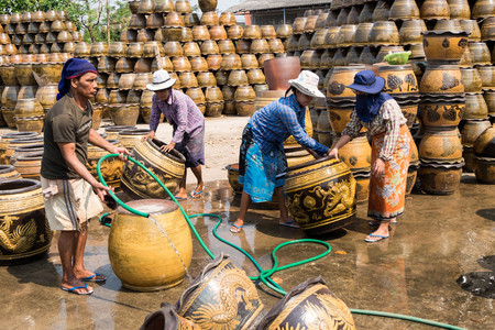 March 4, 2017 - Ratchaburi, Thailand: Male and female workers washing Dragon pattern flower pots.のeditorial素材