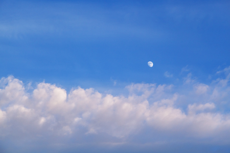 The moon in the sky in the daytime with the cloud against the blue sky background. Natural background.の写真素材