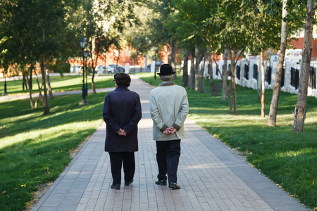 A couple of elderly pensioners walk on the garden path in the Park. Fifty years together. Love story of elderly people.の写真素材