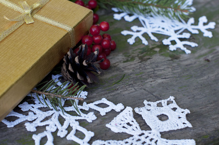 background of Christmas presents and white knitted snowflakes and angel on a rustic wood background