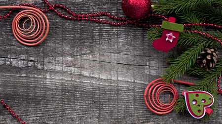 Christmas card with decorative symbol: fir-tree branches, snowman, gift, curl, cones on a wooden background.の写真素材