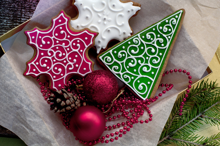 Christmas gingerbreads in the form of white and red snowflakes and a green fir-tree in boxの写真素材