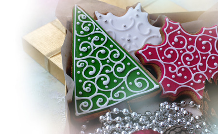 Christmas gingerbreads in the form of white and red snowflakes and a green fir-tree on white backgroundの写真素材
