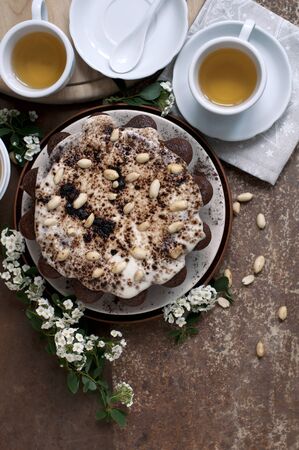 Chocolate cake with peanuts on table with tea and flowersの写真素材