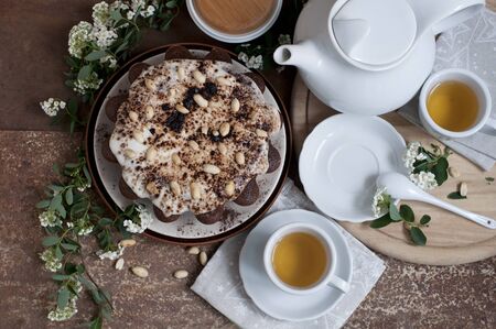 Chocolate cake with peanuts on table with tea and flowersの写真素材