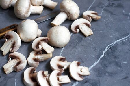 Sliced mushrooms champagne and knife on grayの写真素材