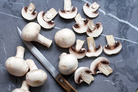Sliced mushrooms champagne and knife on grayの写真素材