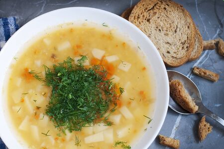 Pea soup with dill, grens and crumbs on dark gray background. Top viewの写真素材