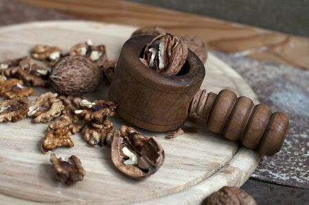 Walnuts in peel and without peel, device for breaking nuts on wooden backgroundの写真素材