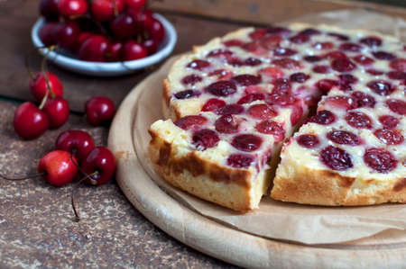 Tart with ripe sweet cherries and green tea on brown background. Homemade dessert with ripe sweet cherries.の写真素材