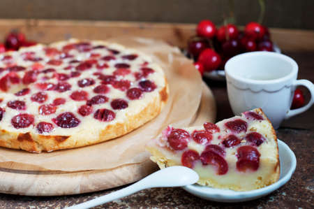 Tart with ripe sweet cherries and green tea on brown background. Homemade dessert with ripe sweet cherries.の写真素材