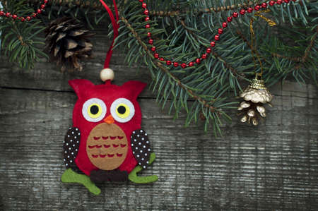 New Year and Christmas card with owl, bell, fir branches, cones on a wooden background. A postcard with Christmas decorations.の写真素材