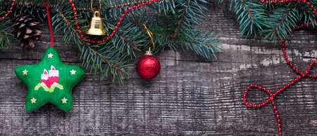 New Year and Christmas card with star, bell, fir branches, cones on a wooden background. A postcard with Christmas decorations.の写真素材