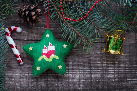 New Year and Christmas card with handmade star, drum, fir branches, cones on a wooden background. A postcard with Christmas decorations.の写真素材