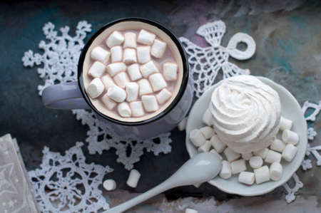 Christmas cup of cocoa with marshmelow on gray background. Cup of New Year's and Christmas cocoa with marshmallows, knitted white snowflakes, sweets and Christmas decorations. Top viewの写真素材