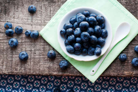 Blueberries on a white plate with a spoon on a wooden gray background. Top viewの写真素材