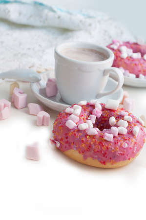 Romantic breakfast with pink donuts, cocoa and pink marshmallows in the shape of heart on white background. Breakfast for Valentines Dayの写真素材