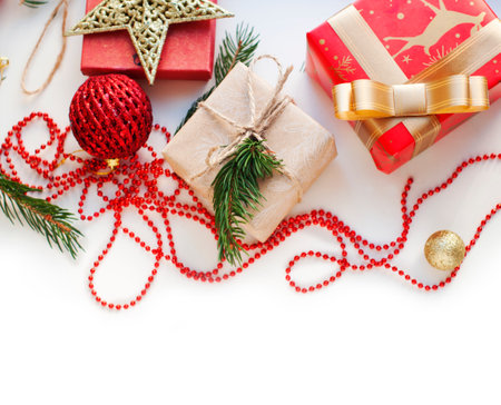 Boxes with gifts in red, gold and beige paper with ribbons, beads, star, spruce branch. Christmas gifts with New Year's decor on a white background. Place for text. Top viewの写真素材