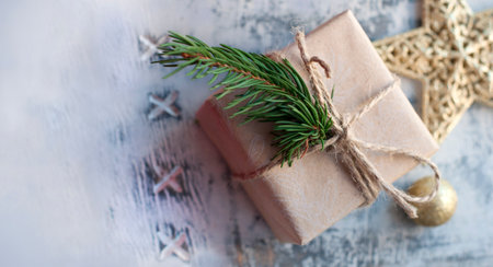 Boxes with gifts in beige paper with ribbons, fir branch. Christmas gifts with New Year's decor on a gray wooden background. Place for text. Top viewの写真素材