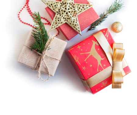Boxes with gifts in red, gold and beige paper with ribbons, beads, star, spruce branch. Christmas gifts with New Year's decor on a white background. Place for text. Top viewの写真素材
