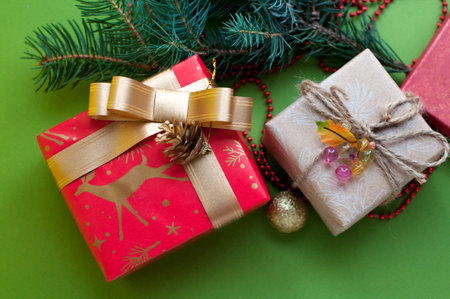 Christmas gift boxes with ornaments and fir branches on green backgroundの写真素材