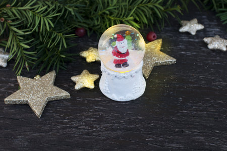 Christmas still life with ball with Santa Claus, shining stars and tangerines on wooden backgroundの写真素材