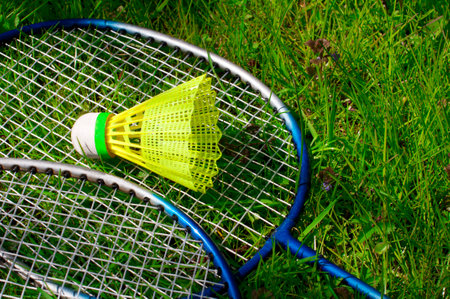 Badminton rackets and shuttlecock on green grass background.の写真素材
