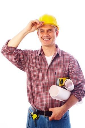 handsome man - builder with drawings smiles and adjusts his helmet handの写真素材