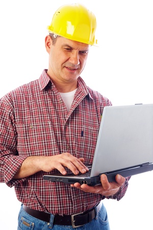 handsome man-builder in helmet examining on a laptop on a white background の写真素材