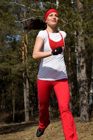 Beautiful young  woman jogging cross countryの写真素材