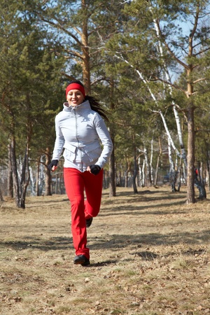 Beautiful young  woman jogging cross countryの写真素材