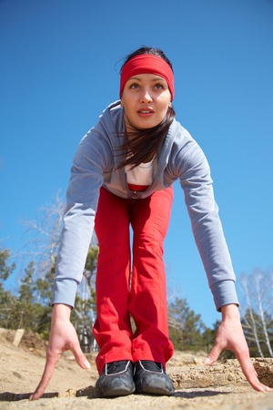Beautiful girl engaged in sports exercises on the nature of the blue summer skyの写真素材