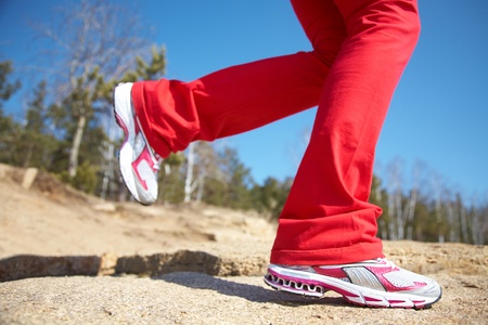 Close-up legs of a girl jogging on the woodの写真素材