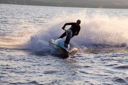 strong man riding on jet skis in the sea at sunset.  silluetの写真素材