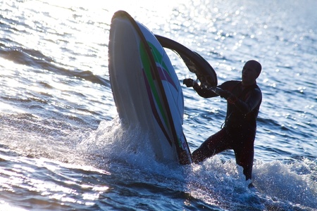 strong man emerges on jet skis over the water at sunset .silluetの写真素材
