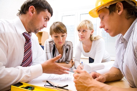 Meeting the team of engineers working on a construction project at the tableの写真素材
