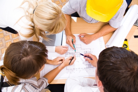 Meeting the team of engineers working on a construction project at the tableの写真素材