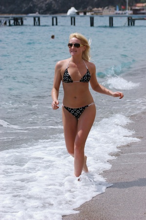 Sexy woman in bikini running along the sea coast, の写真素材