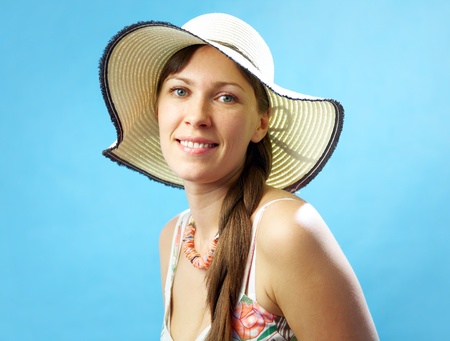 Portrait attractive brunette woman in big hat and on the blue backgroundの写真素材