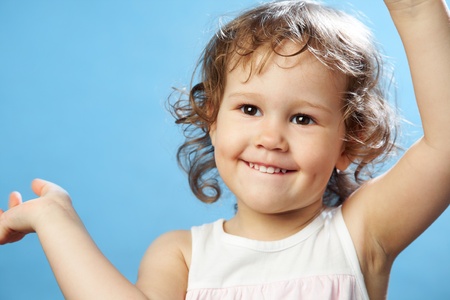 Portrait of funny lovely little girl on the blue background