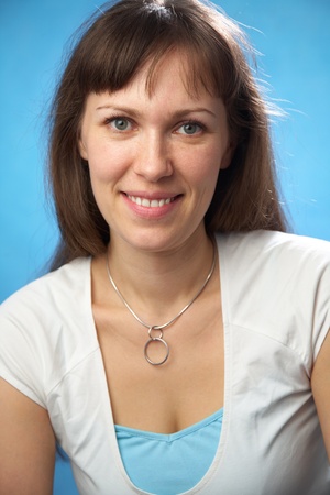 Portrait attractive brunette woman on the blue backgroundの写真素材