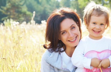 Portrait of  beautiful young woman hugging her little girlの写真素材