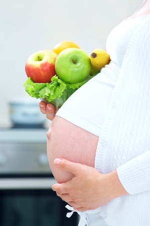 unrecognizable pregnant woman with healthy food in kitchenの写真素材
