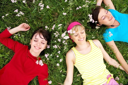 Young pretty women resting on the green grass in summer  の写真素材