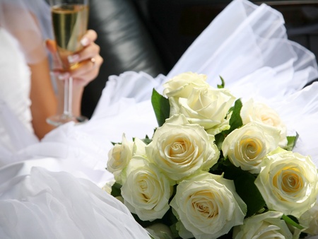The bride with a wedding bouquet and champagne in a carの写真素材