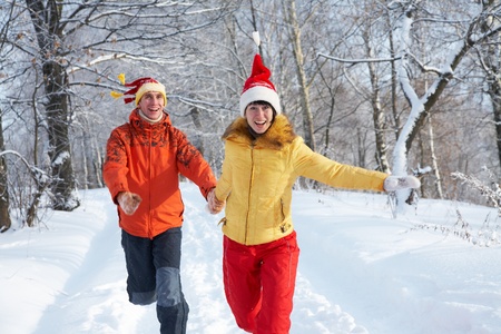 young couple runs on winter woodの写真素材