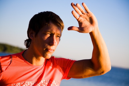 portrait of  beautiful young men in sports clothing at sunset on the beachの写真素材