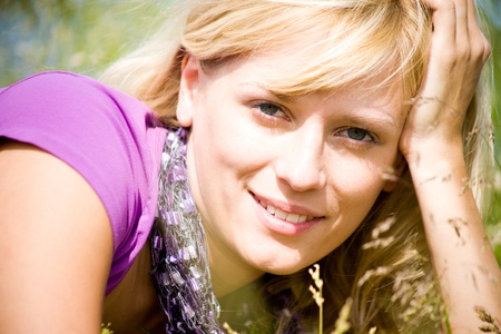 young beautiful woman with fair hair lying and  enjoy on the meadowの写真素材
