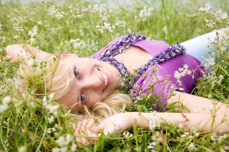 young beautiful woman with fair hair lying on the grassの写真素材